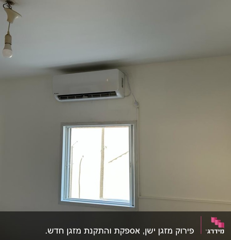 מזגן מותקן על קיר מעל חלון בחדר